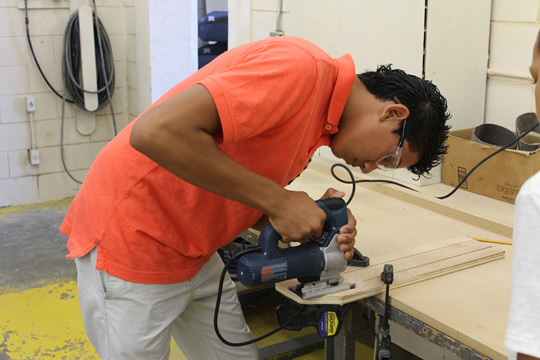 boy cutting wood with a jigsaw 