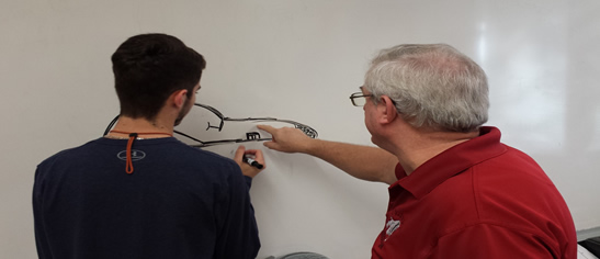 Crestivew High School instructor drawing diagram on whiteboard with student